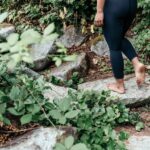 person in black leggings walking on rock